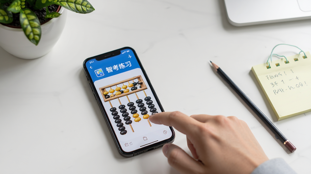 一部手机平放在桌面上,屏幕显示算盘智考练习界面,手机旁边有一只手正在点击屏幕,背景为整洁的书桌与绿植,布局手机居中偏左,右侧留白放置铅笔与便签,风格生活化学习场景,细节真实,画质干净,无多余元素