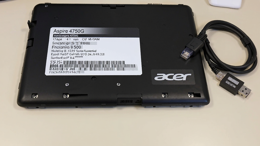һ��չʾAcer��Aspire 4750G�ʼǱ��ײ���ǩ����дͼƬ����ǩ��ӡ���ͺź����кţ��Ա߰ڷ���һ�����ߺ�һ��USB����������������������������Ϊǳɫ���棬�Ű��࣬���дʵ�����ʸɾ����޶���Ԫ�ء�