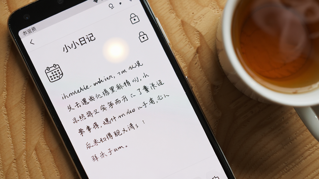 һ����׿�ֻ���Ļ��д����������ʾСС�ռǵı༭���棬���ױ�������һ������д�����֣��Ա���һ��С������ͼ�������ͼ�꣬�ֻ�������ľ�������ϣ��Ա���һ���Ȳ裬���岼��Ϊ���ӽǶȣ������ů������ϸ������Ļ����΢���⣬���������ɾ����޶���Ԫ�أ���������Ϊ��СС�ռǡ�